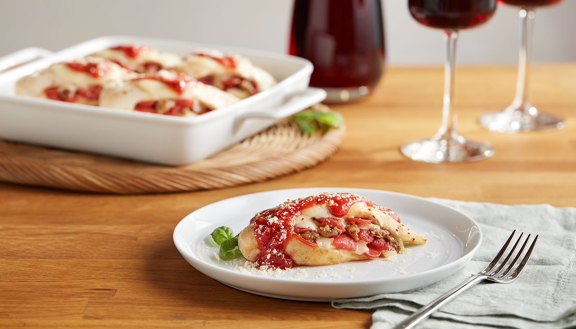 Pizza Stuffed Chicken Image of Pizza Stuffed chicken chicken breast stuffed with pizza ingredients on white plate wood table