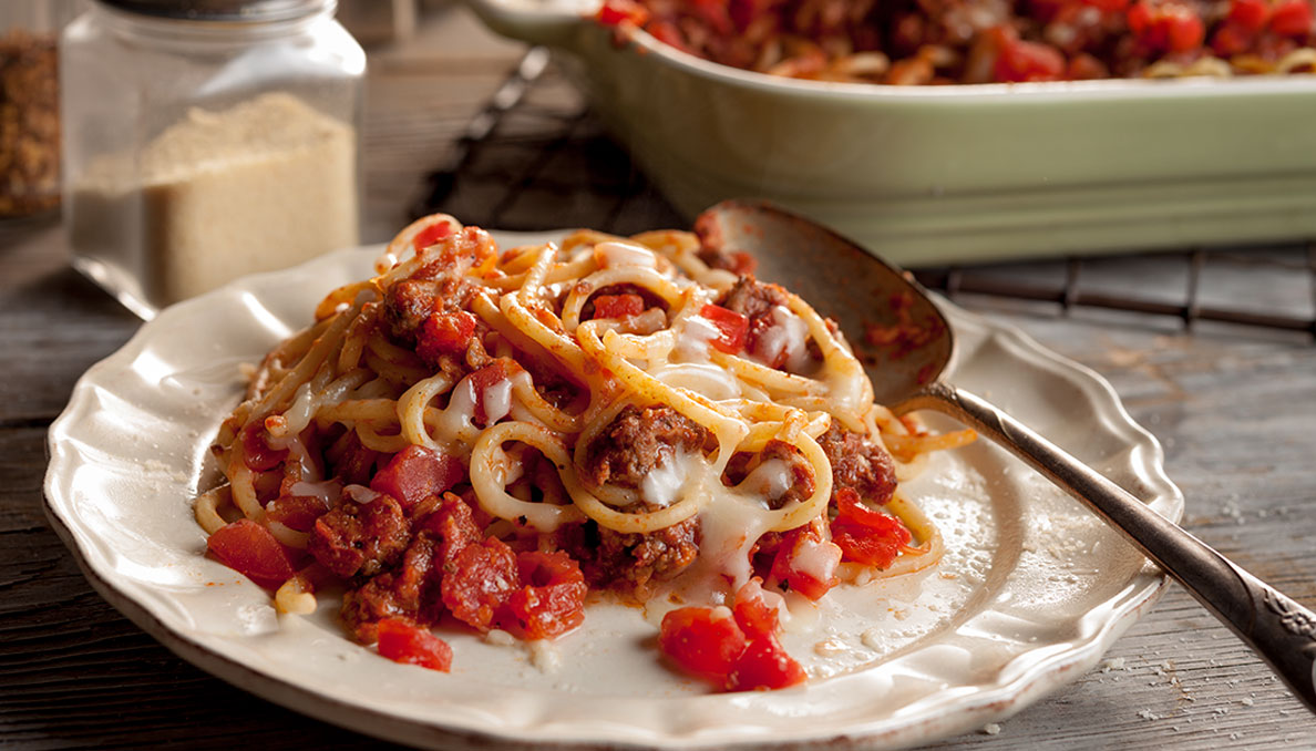 Image of Baked Spaghetti with diced tomatoes scooped onto dish