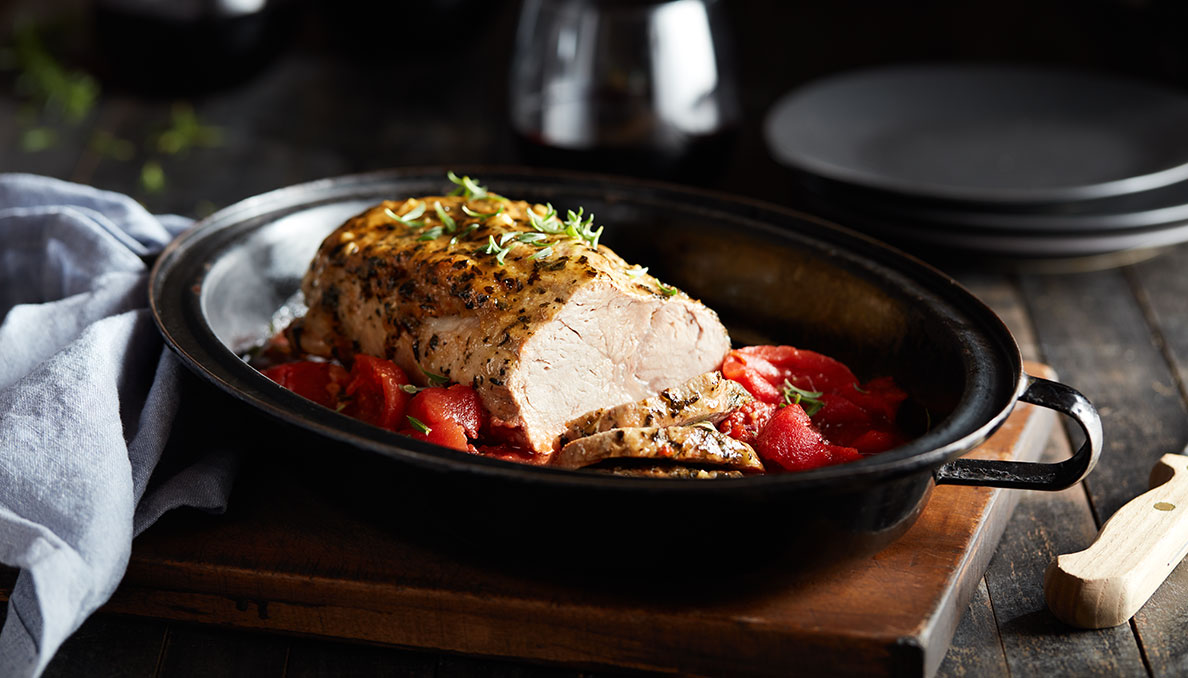Parmesan-Pork-Roast Image of pork loin with canned tomatoes in a black slow cooker insert