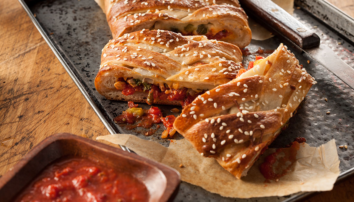 Image of Pizza stromboli cut into slices on sheet tray