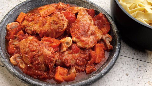 Image of Rustic Italian Chicken on plate with vegetables pasta in background